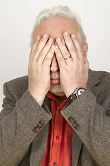 Image showing Senior hands his face