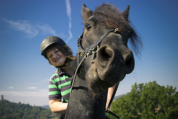 Image showing Beautiful young woman rides her black Horse 