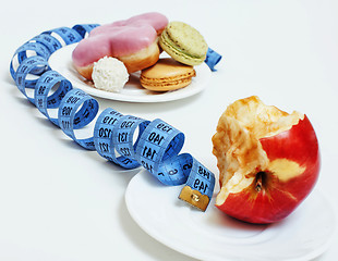 Image showing new real diet concept, question sign in shape of measurment tape between red apple and donut isolated on white 