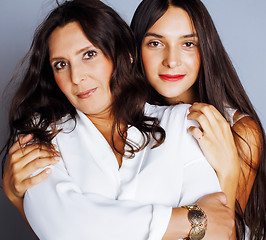 Image showing cute pretty teen daughter with mature mother hugging, fashion st