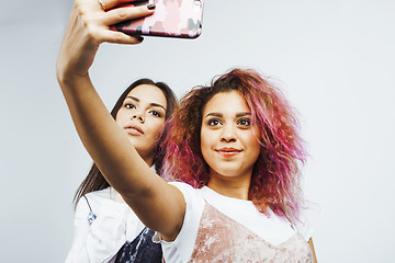 Image showing lifestyle people concept: two pretty stylish modern hipster teen girl having fun together, diverse nation mixed races, happy smiling making selfie 