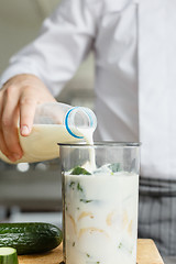 Image showing Male pouring milk while preparing smoothie