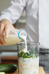 Image showing Male pouring milk while preparing smoothie
