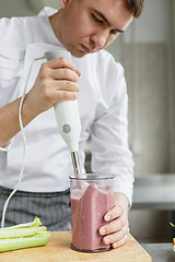 Image showing Young male preparing smoothie