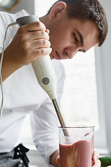 Image showing Young male preparing smoothie