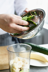 Image showing Crop hands making fresh smoothie