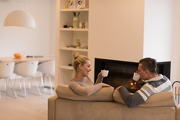 Image showing Young couple  in front of fireplace