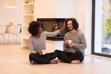 Image showing multiethnic couple  in front of fireplace