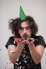 Image showing man blowing confetti in the air