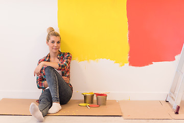 Image showing young female painter sitting on floor