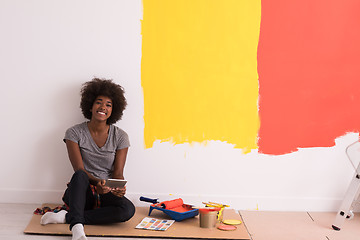 Image showing back female painter sitting on floor