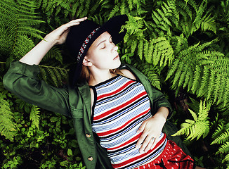 Image showing Pretty young blond girl hipster in hat among fern, vacation in green forest, lifestyle fashion people concept