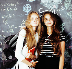 Image showing back to school after summer vacations, two teen real girls in classroom with blackboard painted together, lifestyle people concept close up