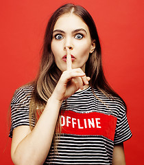 Image showing young pretty emitonal posing teenage girl on bright red background, happy smiling lifestyle people concept 