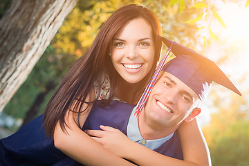 Image showing Happy Male Graduate in Cap and Gown and Pretty Girl Celebrate Ou