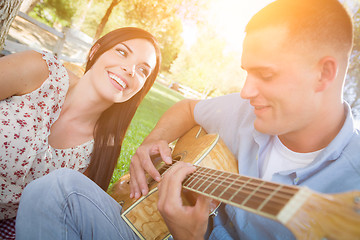 Image showing Happy Mixed Race Couple at the Park Playing Guitar and Singing S