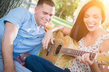 Image showing Happy Mixed Race Couple at the Park Playing Guitar and Singing S