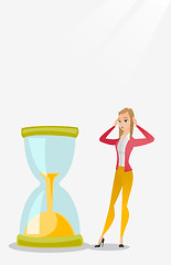 Image showing Desperate business woman looking at hourglass.