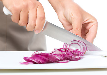 Image showing Cook is chopping onion