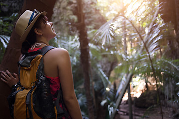 Image showing Woman in hat among palms