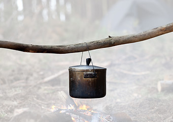 Image showing Cooking in sooty cauldron on campfire