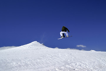 Image showing Snowboarder jump in terrain park at ski resort on sun winter day