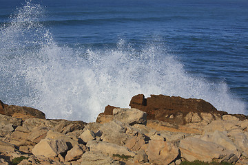 Image showing Marine wave breaks against offshore stone