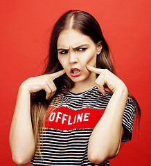 Image showing young pretty emitonal posing teenage girl on bright red background, happy smiling lifestyle people concept 