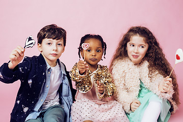 Image showing lifestyle people concept: diverse nation children playing together, caucasian boy with african little girl holding candy happy smiling 