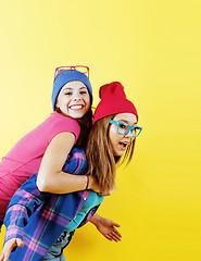 Image showing lifestyle people concept: two pretty young school teenage girls having fun happy smiling on yellow background 