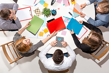 Image showing Team sitting behind desk, checking reports, talking. Top View