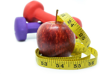 Image showing Dumbbell with measuring tape and red apple