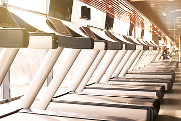 Image showing Woman running in a gym on a treadmill concept for exercising, fitness and healthy lifestyle