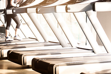 Image showing Woman running in a gym on a treadmill concept for exercising, fitness and healthy lifestyle