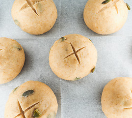 Image showing Pumkin seed buns proofing on baking paper at close-up