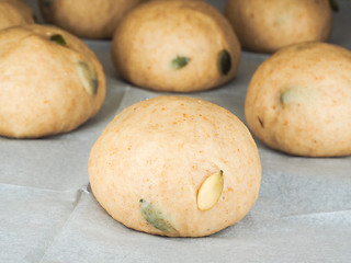 Image showing Pumkin seed buns proofing on baking paper at close-up