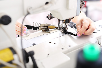 Image showing Production of apparel. Occupation needlewoman. Sewing underwear.