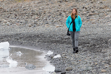 Image showing Woman walking over the beach at Jokulsarlon glacier lagoon - Ice