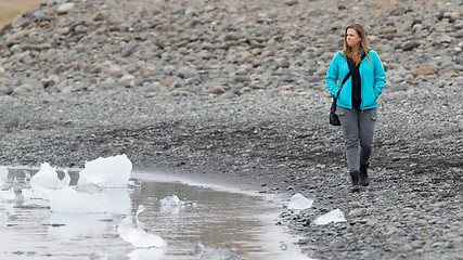 Image showing Woman walking over the beach at Jokulsarlon glacier lagoon - Ice