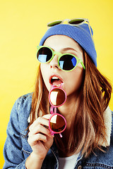 Image showing young pretty long hair teenage hipster girl posing emotional happy smiling on yellow background, lifestyle people concept 