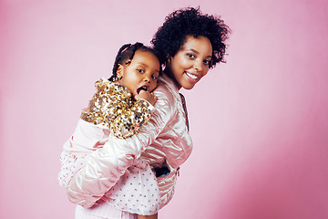 Image showing young pretty african-american mother with little cute daughter hugging, happy smiling on pink background, lifestyle modern people concept 