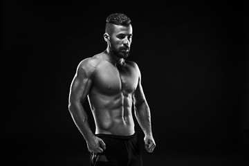 Image showing The torso of attractive male body builder on black background.