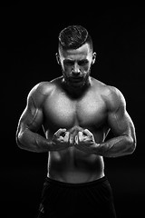 Image showing The torso of attractive male body builder on black background.