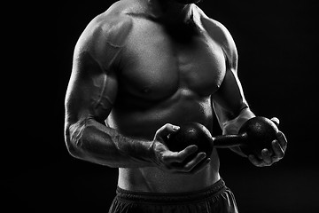 Image showing The torso of attractive male body builder on black background.