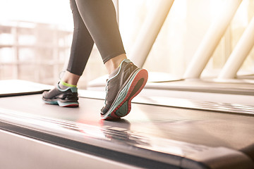 Image showing Woman running in a gym on a treadmill concept for exercising, fitness and healthy lifestyle