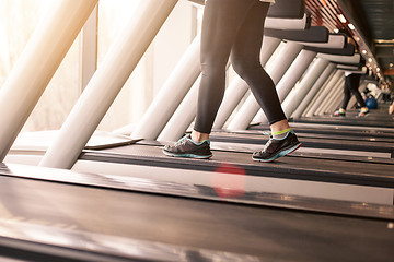 Image showing Woman running in a gym on a treadmill concept for exercising, fitness and healthy lifestyle