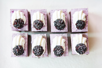 Image showing The rows of sweet and tasty cakes with blackberries.