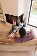 Image showing Young multiethnic couple  in front of fireplace