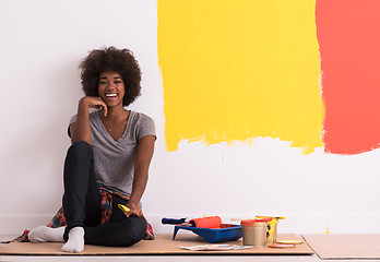 Image showing back female painter sitting on floor