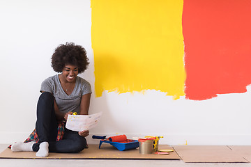 Image showing back female painter sitting on floor